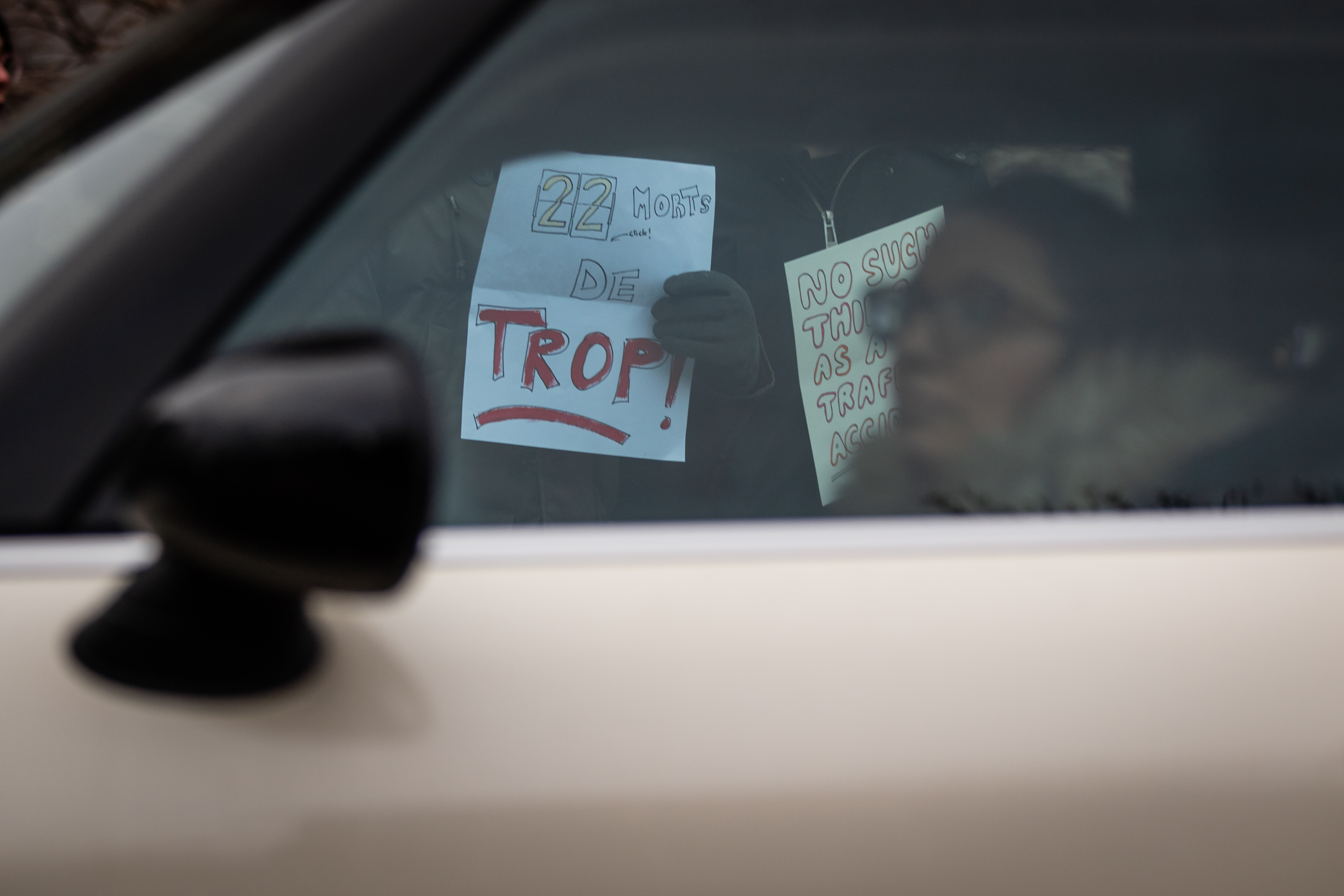 Des manifestants et une voiture au coin de Hutchison et Saint-Joseph, à un rassemblement pour repenser le Code de la sécurité routière