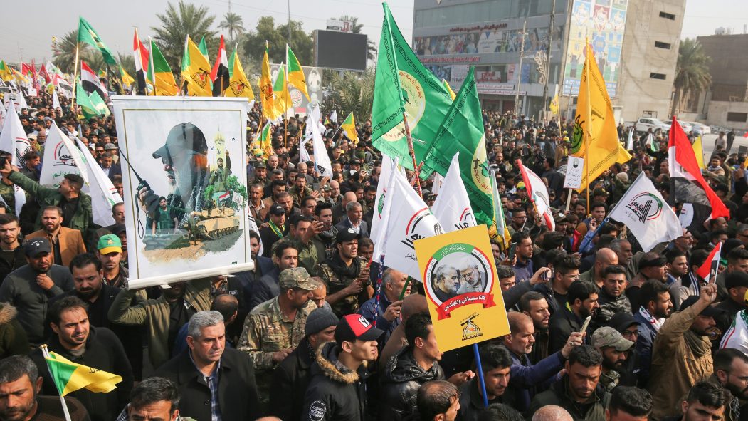 Une foule d'irakiens tenant des drapeaux du Hachd et du Hezbollah lors des obsèques du général iranien Qassem Soleimani, à Bagdad, le 4 janvier 2020.