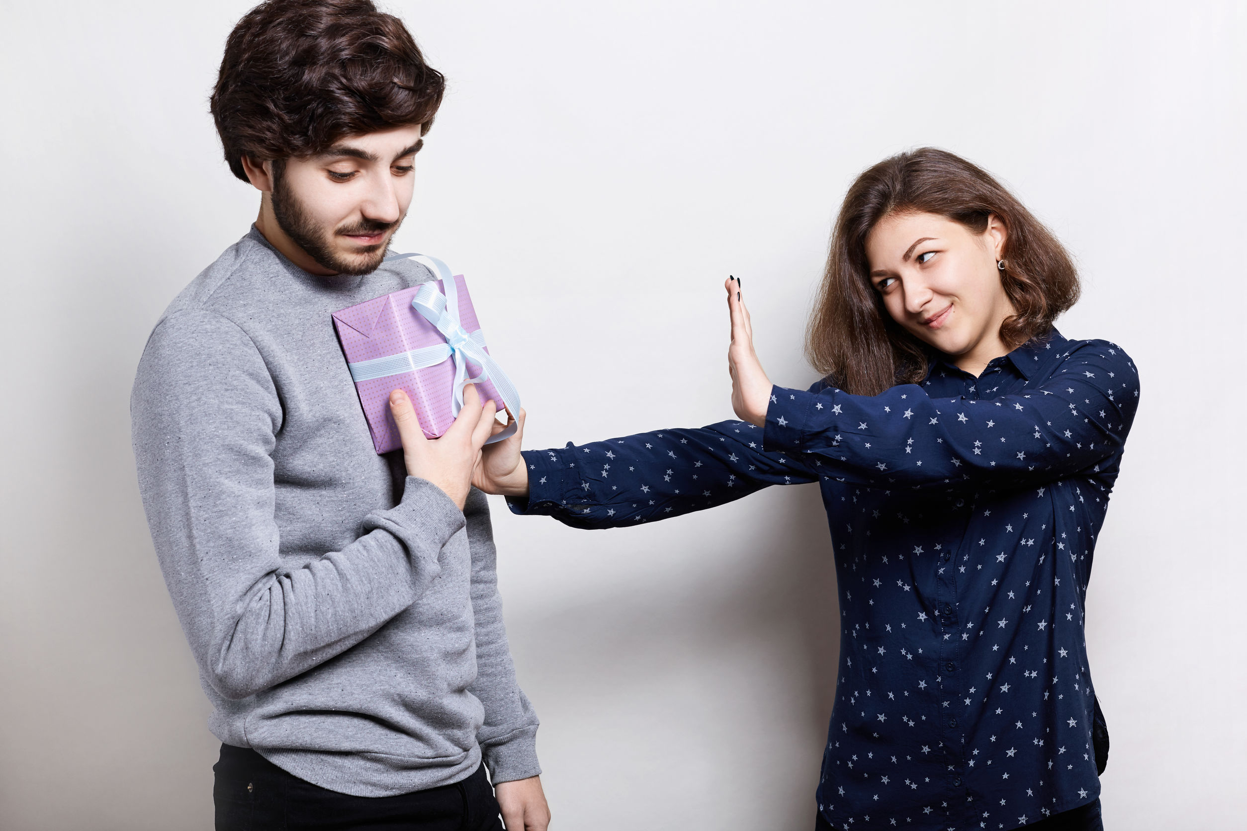 Une jeune femme refuse le cadeau de Noël offert par un jeune homme, présumément son copain.