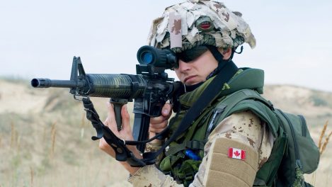 Un soldat de l'armée canadienne en Irak, portant du camouflage de désert et pointant son arme