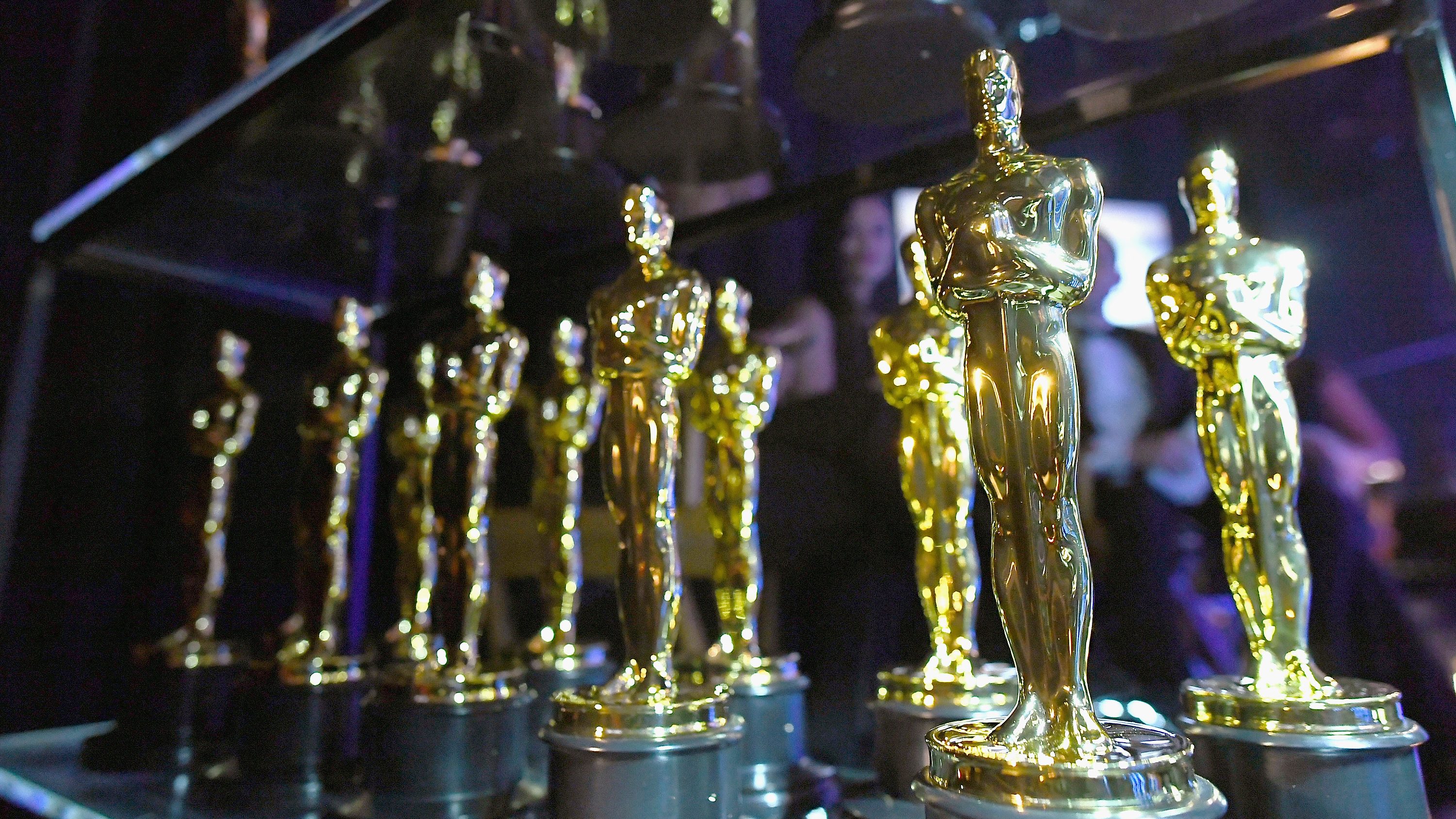 Золотая статуя Оскар на серо черном градиенте. Премия общества независимых кинокритиков Чикаго.