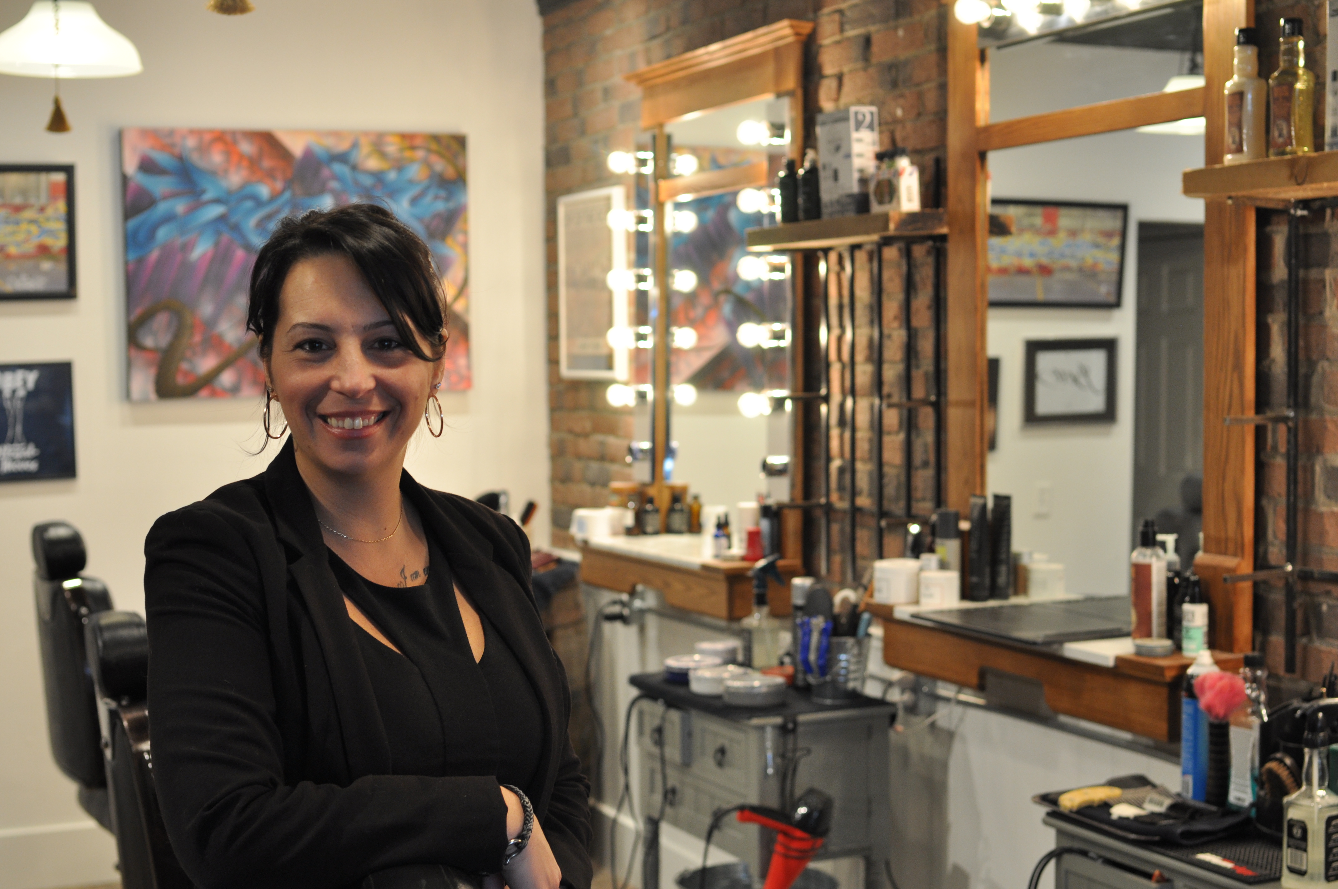 La propriétaire, Mélissa Gaulin se tient devant les chaises de barbiers de son commerce.