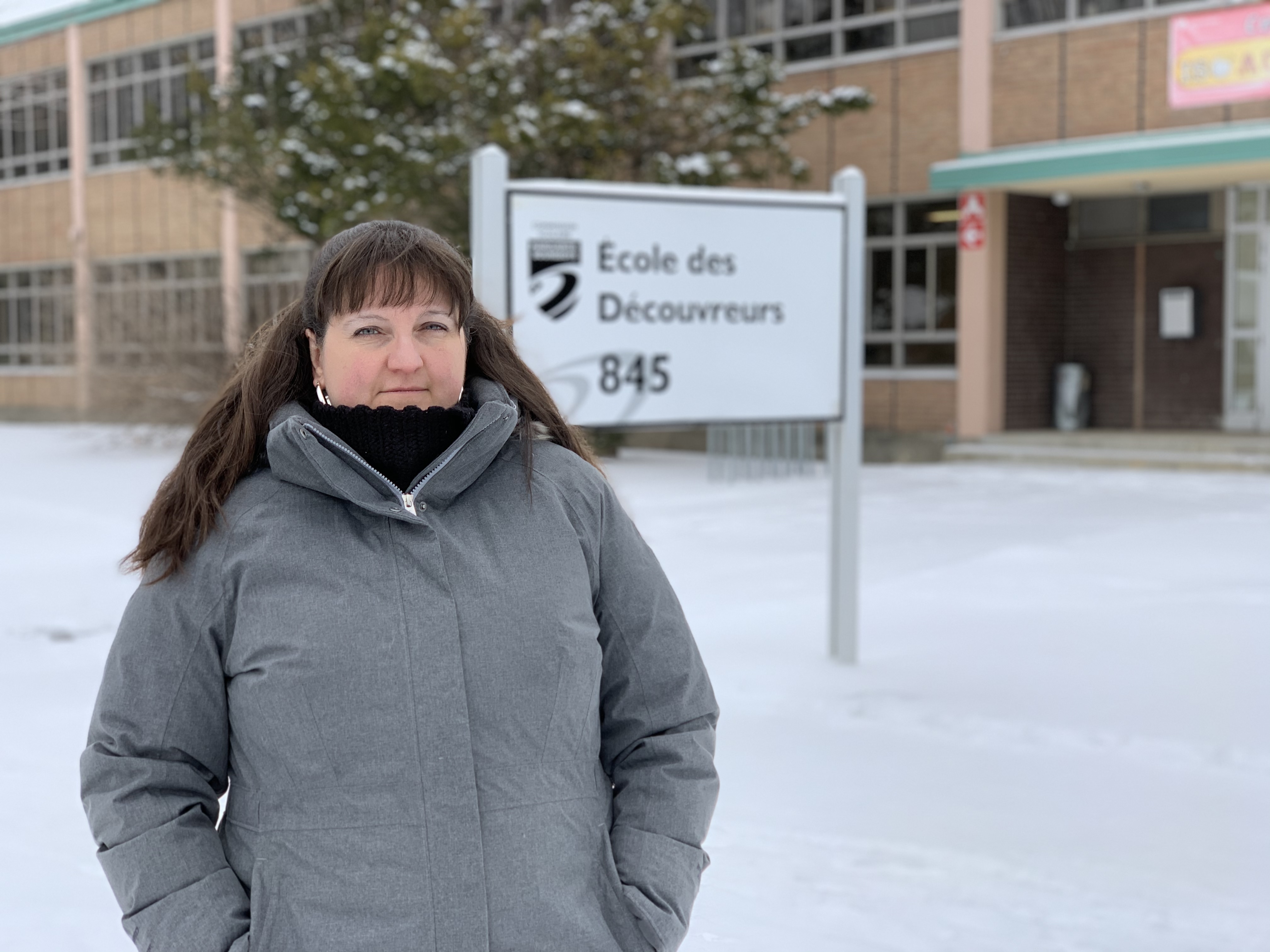 Mélanie Hubert pose devant l'école primaire des Découvreurs