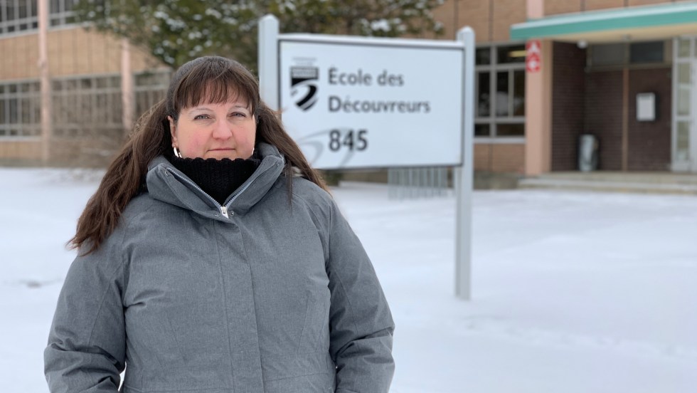 Mélanie Hubert pose devant l'école primaire des Découvreurs