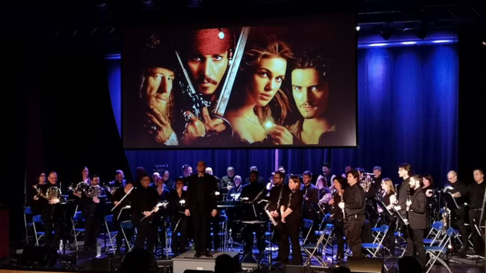 Plusieurs musiciens performent devant un public.