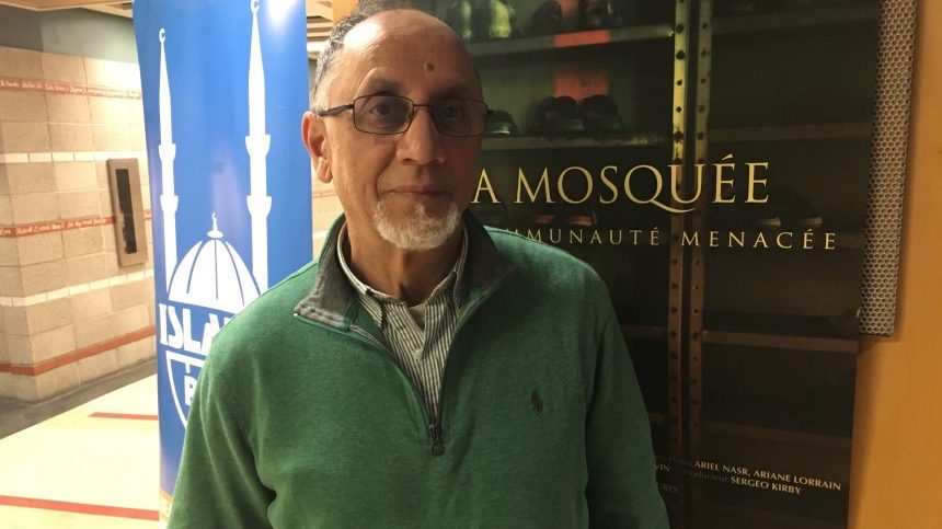 Boufeldja Benabdallah, cofondateur du Centre culturel islamique de Québec, devant une affiche du documentaire sur l'attentat de Québec.