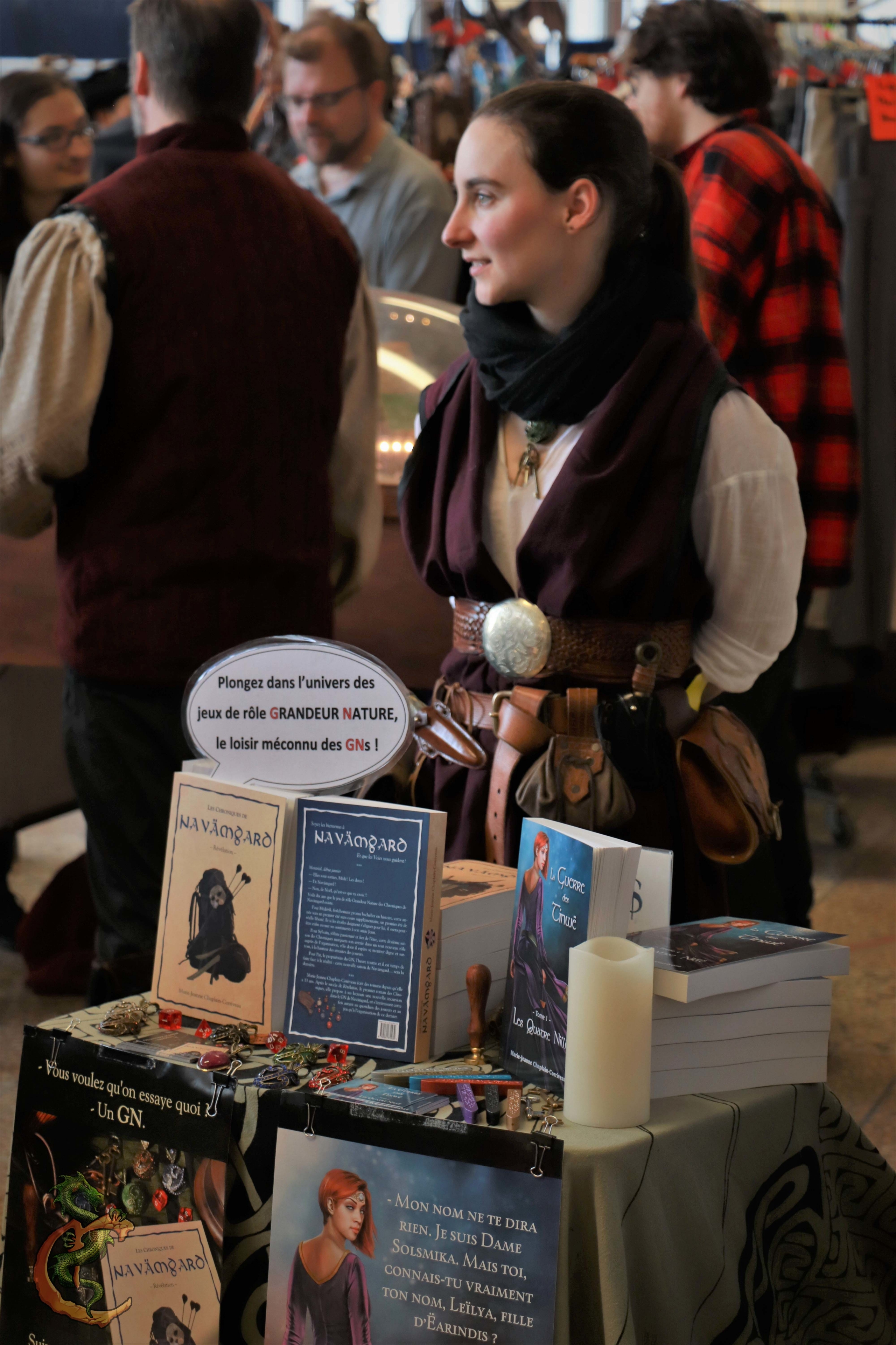 L'auteure Marie-Jeanne-Chaplain-Corriveau de tient devant ses livres lors d'un événement.
