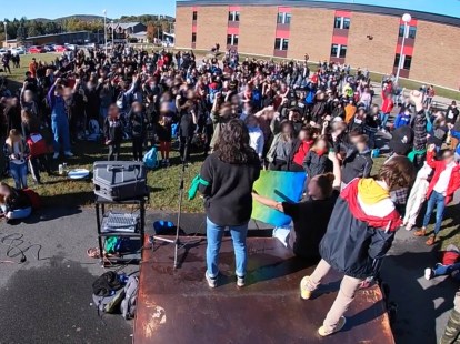Une foule d'élèves d'une école secondaire lève le poing lors d'un vote portant sur la grève du climat.