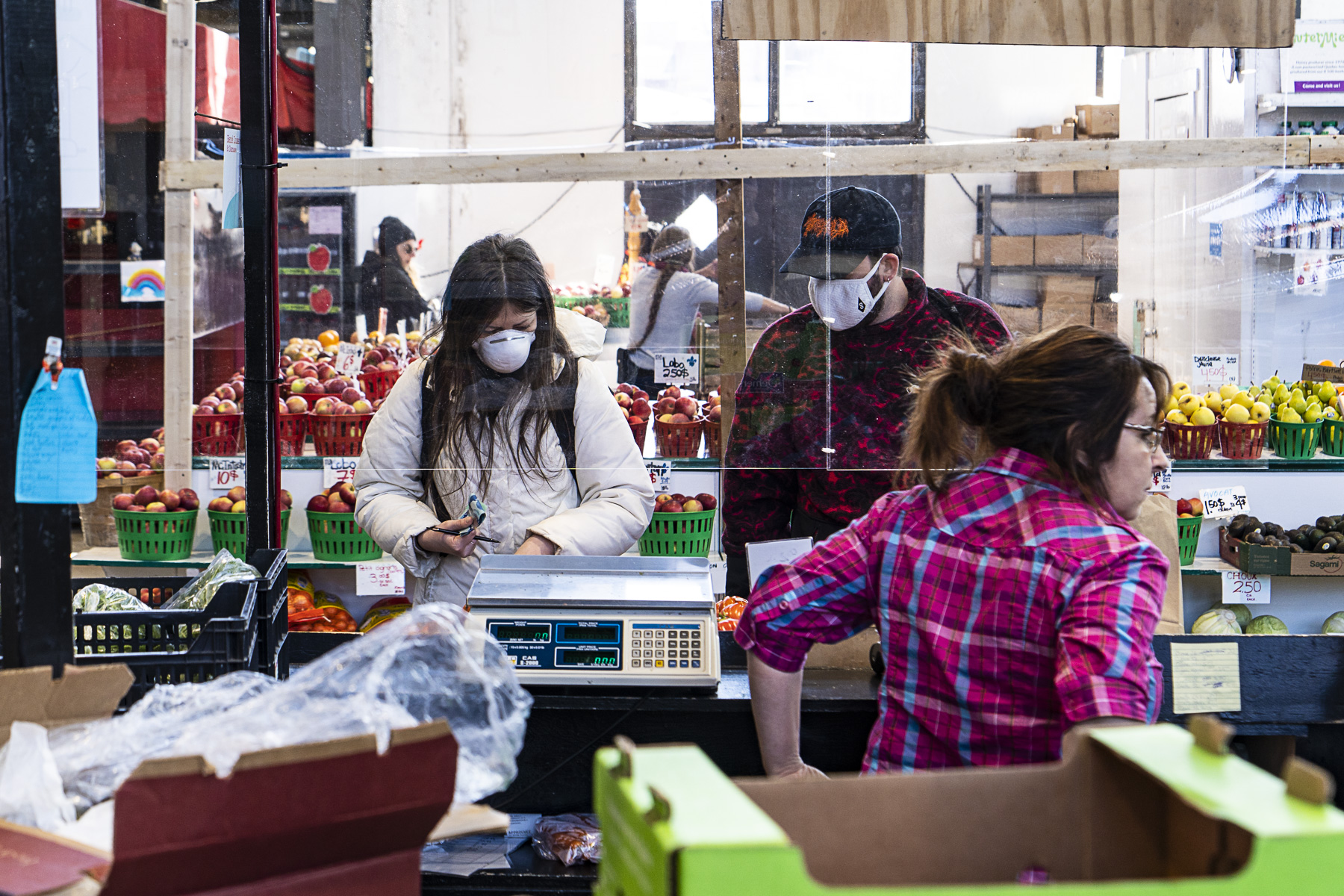 Les étals de fruits et légumes du Marché Jean-Talon protégés par des panneaux de plastique.