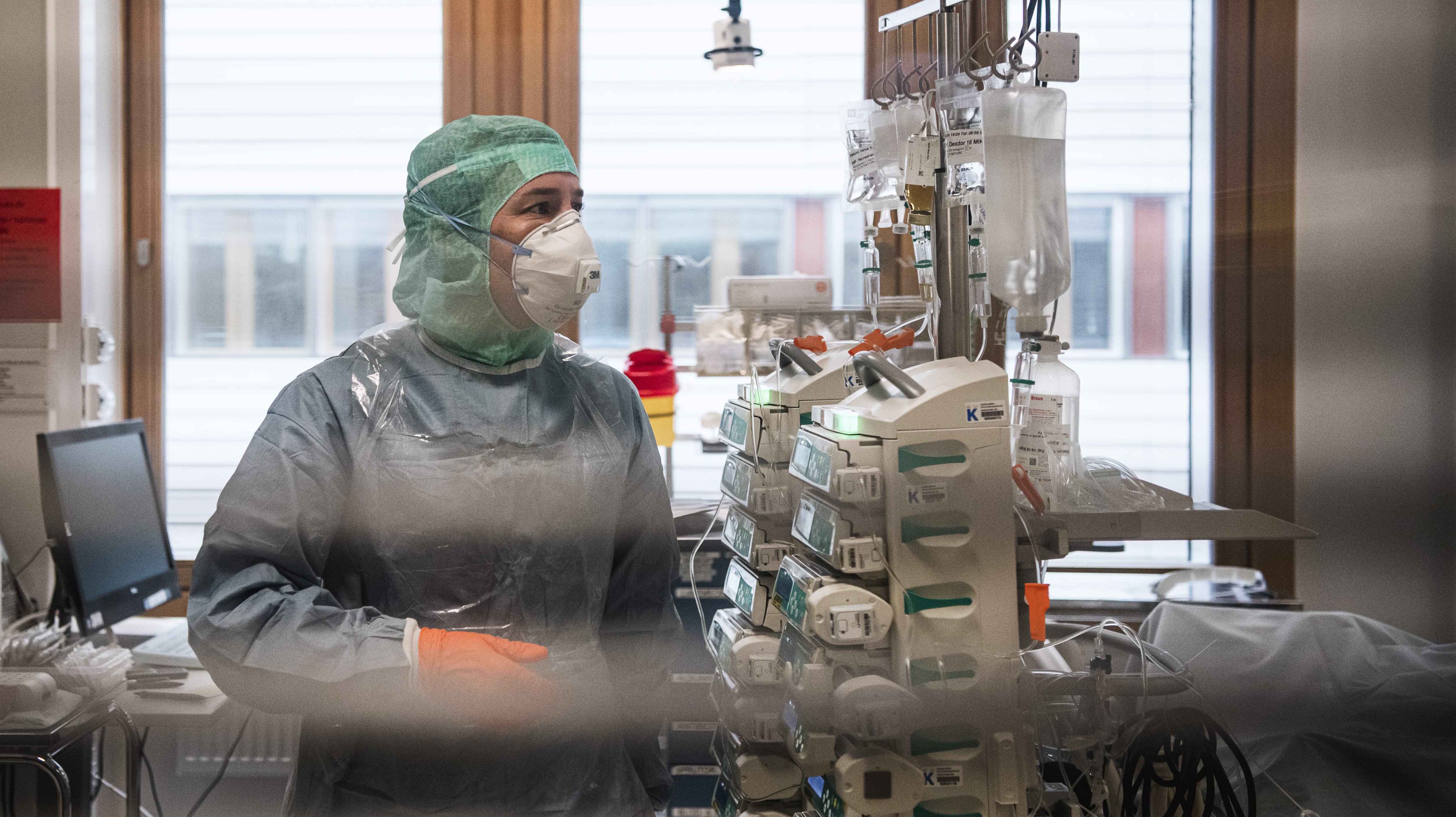 Une personne du corps médical porte une blouse de protection et un masque.