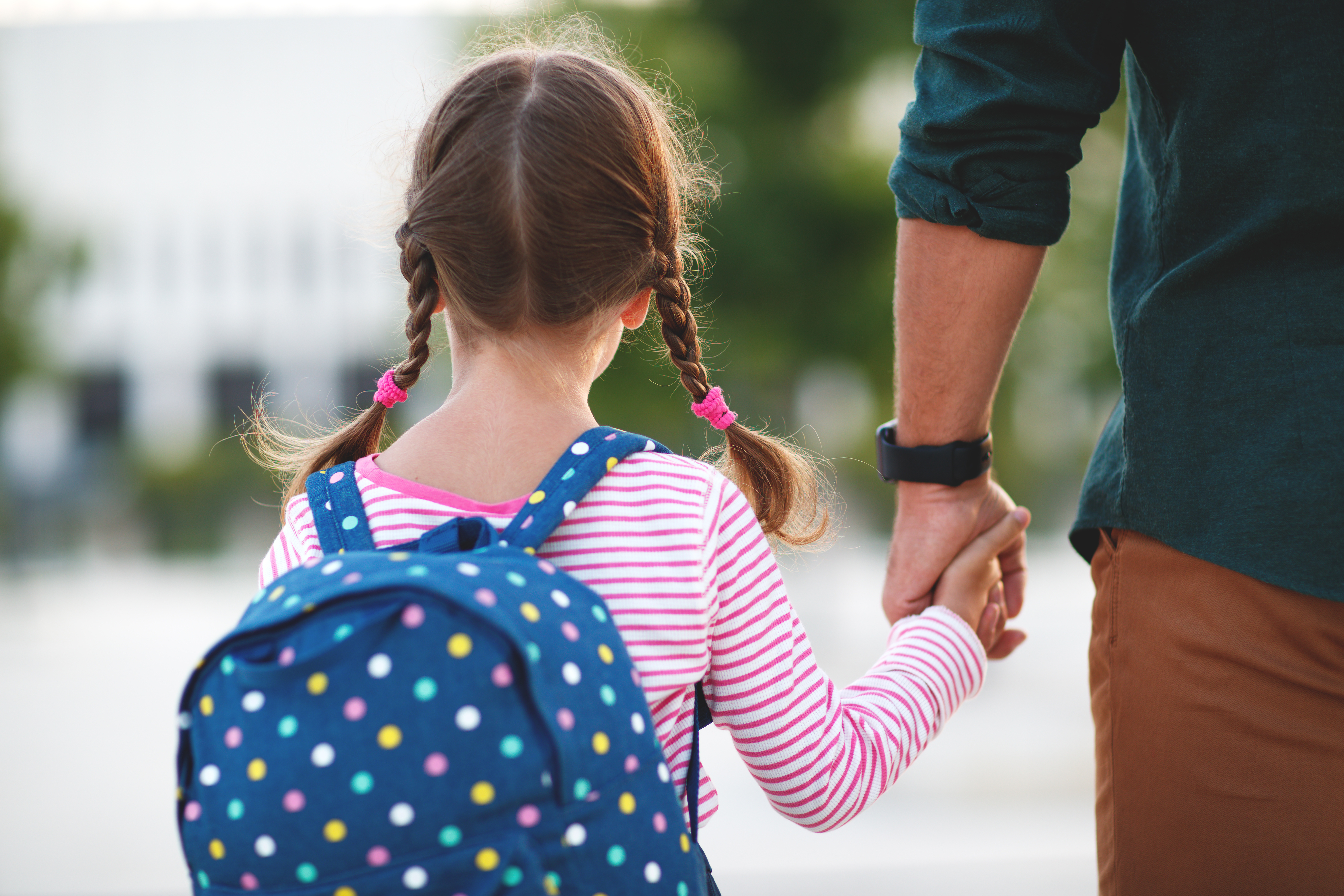 enfant féminin se promenant main dans la main avec un adulte masculin