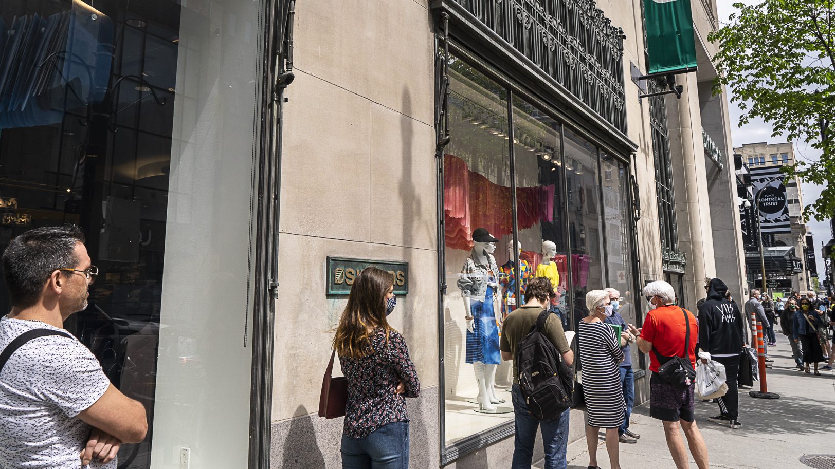 Plusieurs personnes patientent devant le magasin Simons, rue Sainte-Catherine.