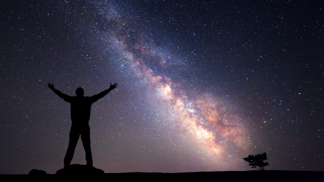 Une silhouette d'un homme se tient devant le ciel nocturne, traversé par la Voie lactée. Selon une nouvelle recherche, la Voie lactée pourrait contenir au moins 36 civilisations extra-terrestres intelligentes.