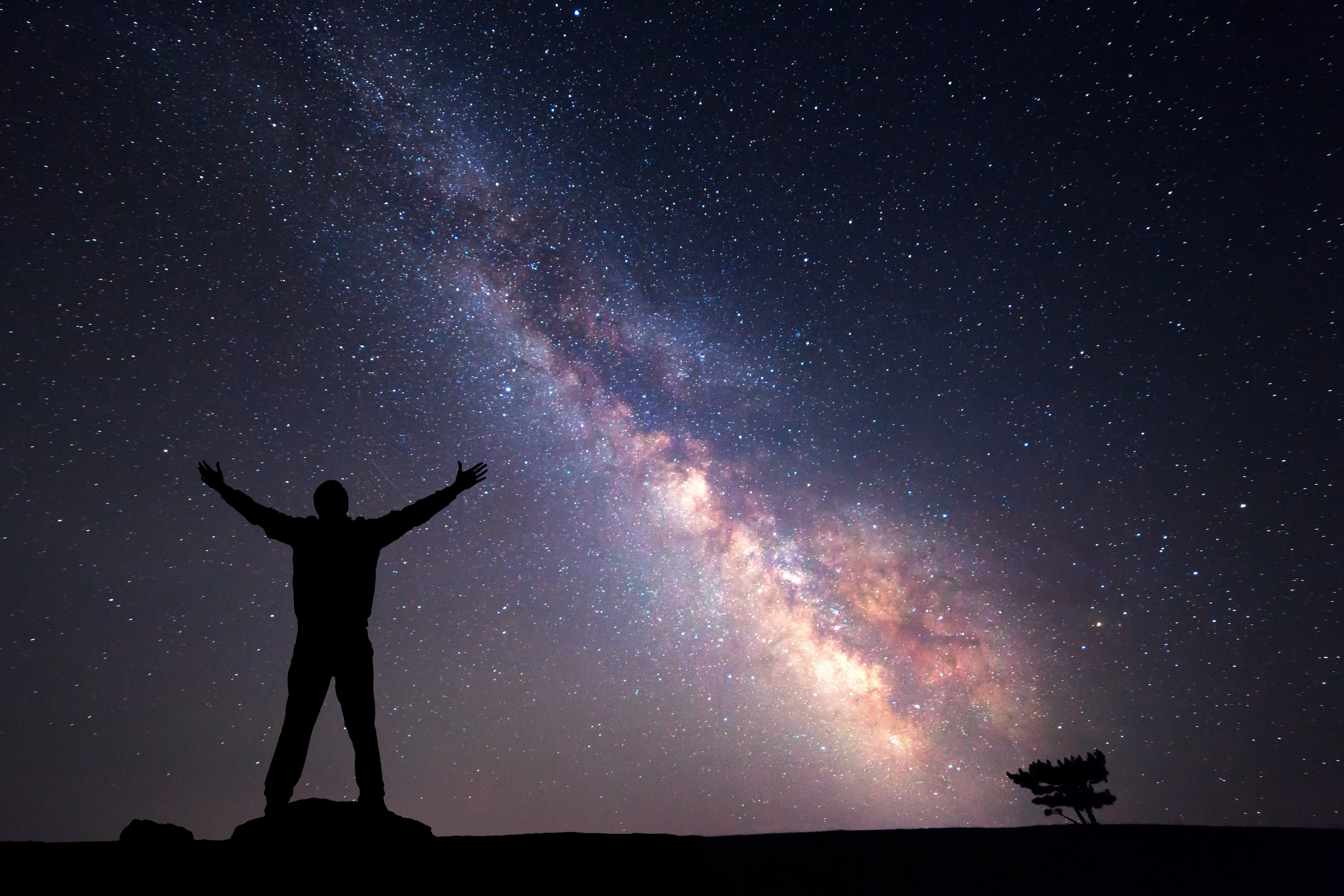 Une silhouette d'un homme se tient devant le ciel nocturne, traversé par la Voie lactée. Selon une nouvelle recherche, la Voie lactée pourrait contenir au moins 36 civilisations extra-terrestres intelligentes.