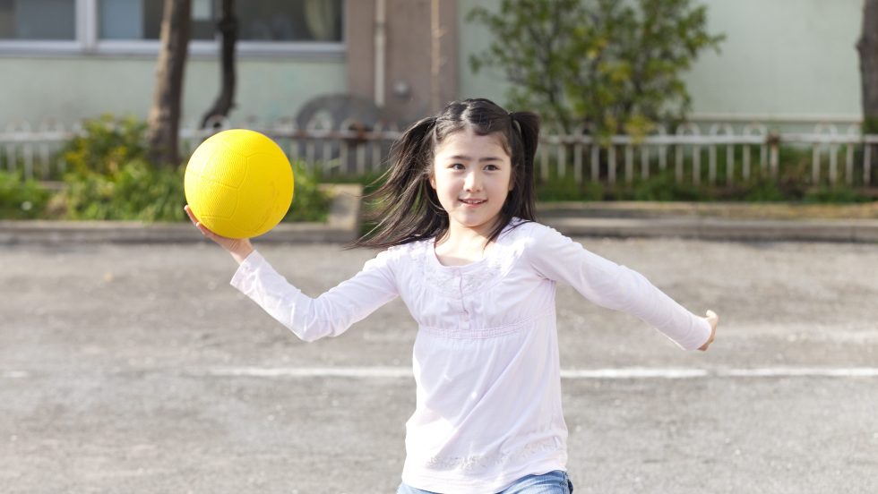 Une jeune fille joue au ballon-chasseur.