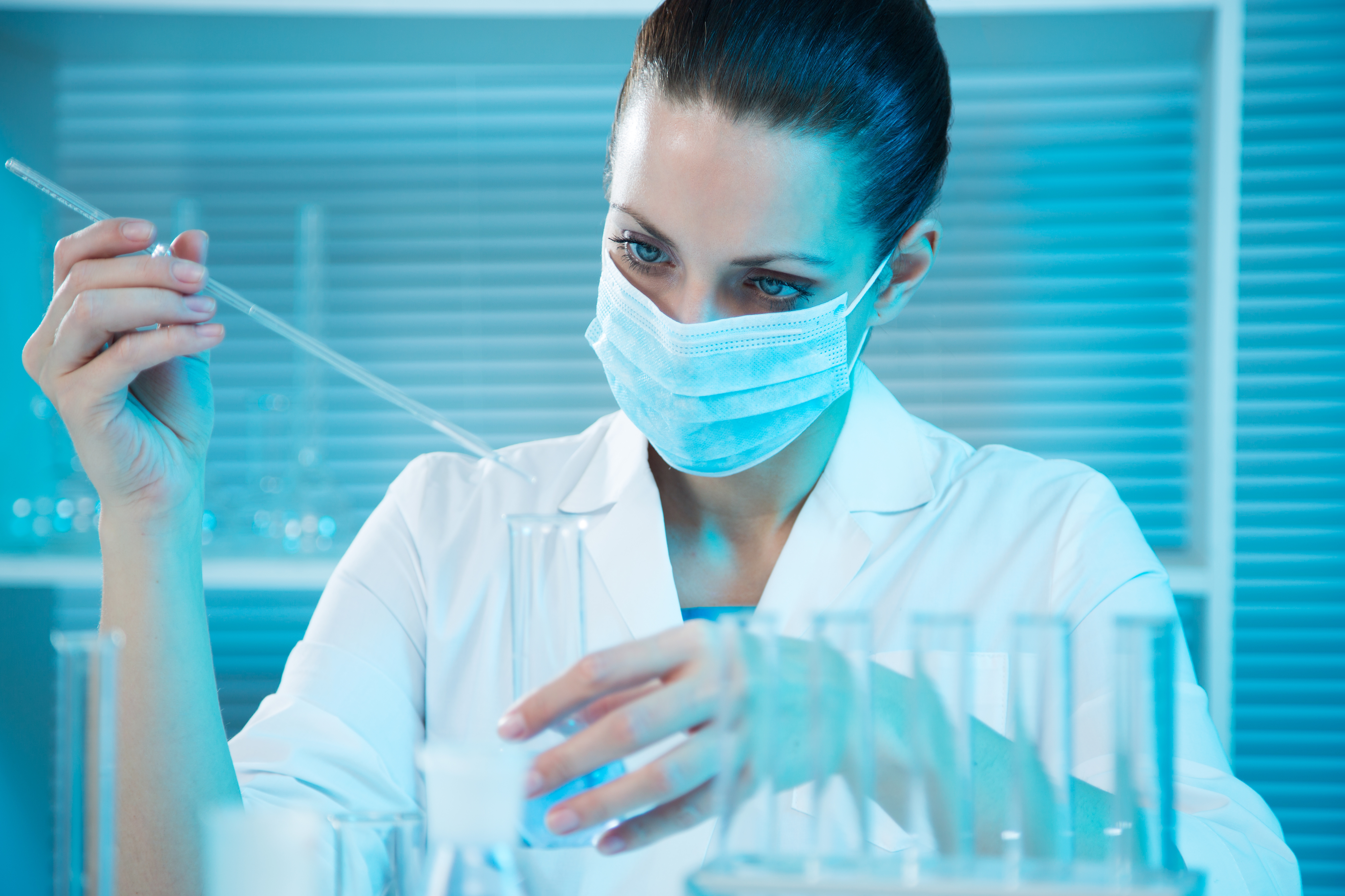 Une femme scientifique menant une recherche mesure un liquide dans un erlenmeyer.