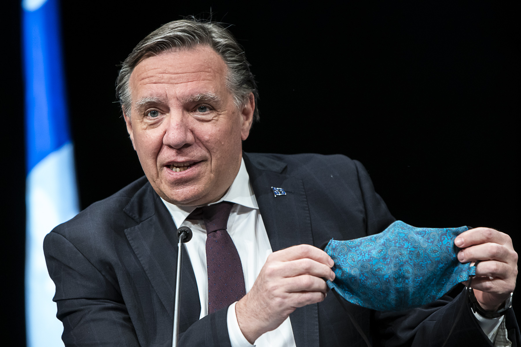 François Legault tient un masque bleu pendant un point de presse portant sur le coronavirus