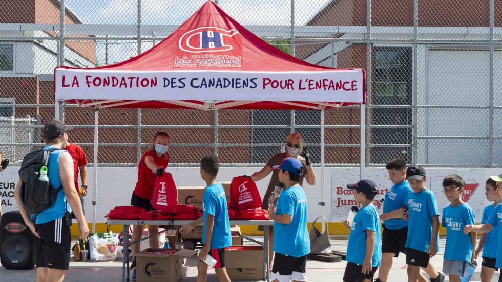Des jeunes attendent en ligne avant de recevoir leur trousse.