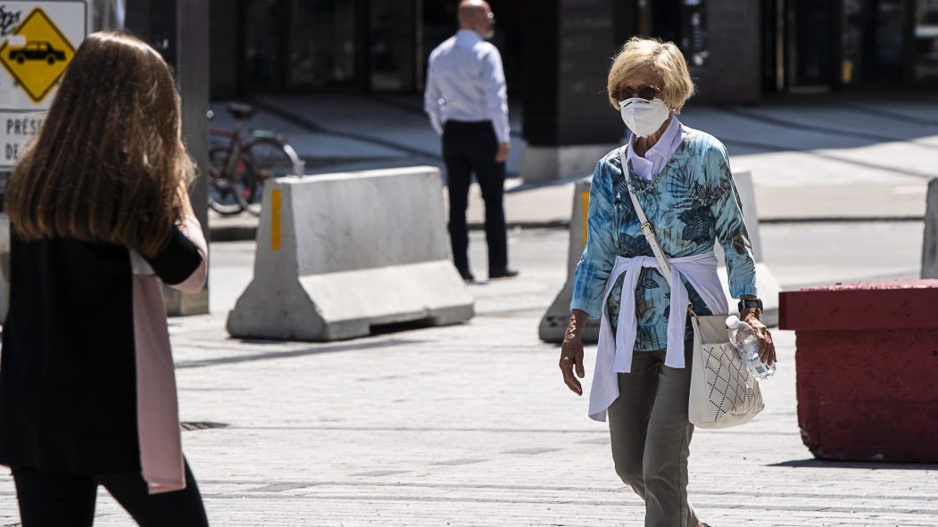 une femme masquée se promène dans la rue pendant la pandémie de covid 19