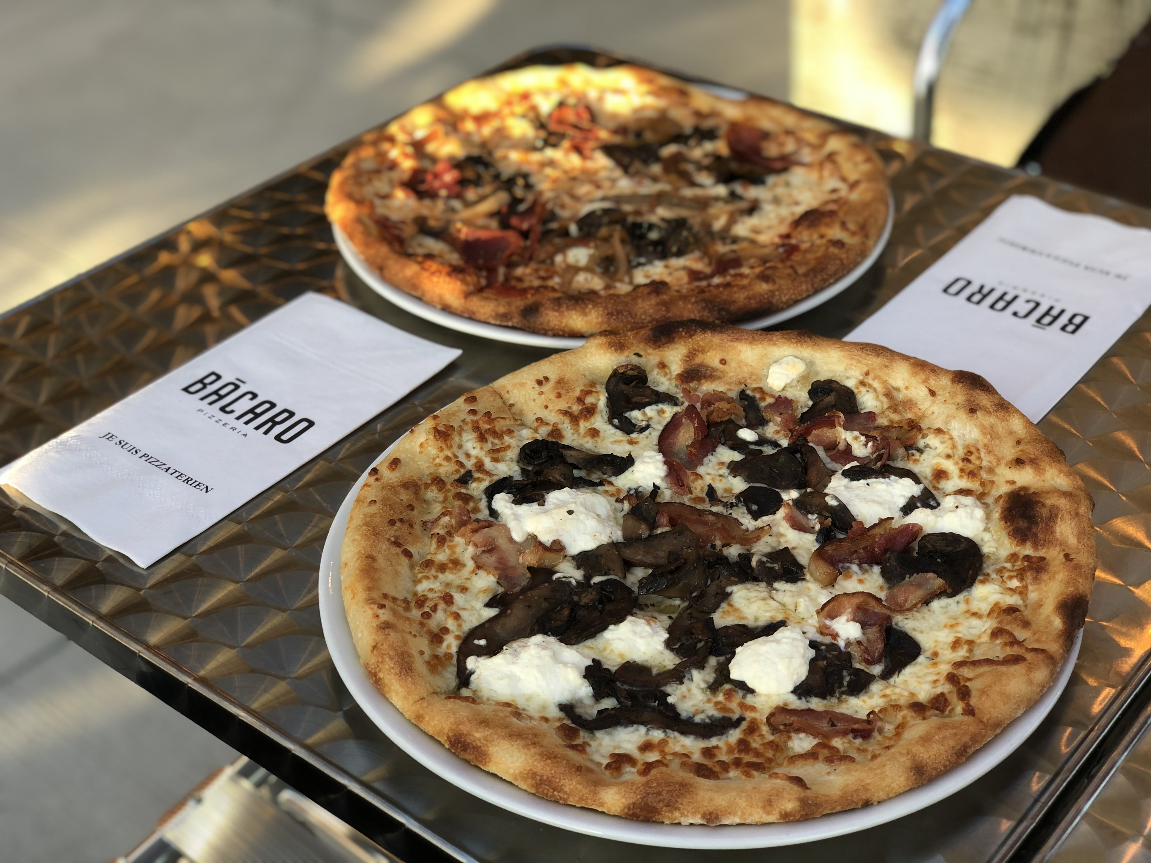 Deux pizzas déposées sur une tables