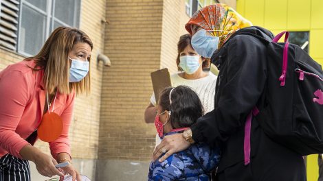 Une enfant masquée est accueillie avec sa mère à l'école primaire Philippe-Labarre, lors de la première rentrée scolaire depuis le début de la pandémie de COVID-19.