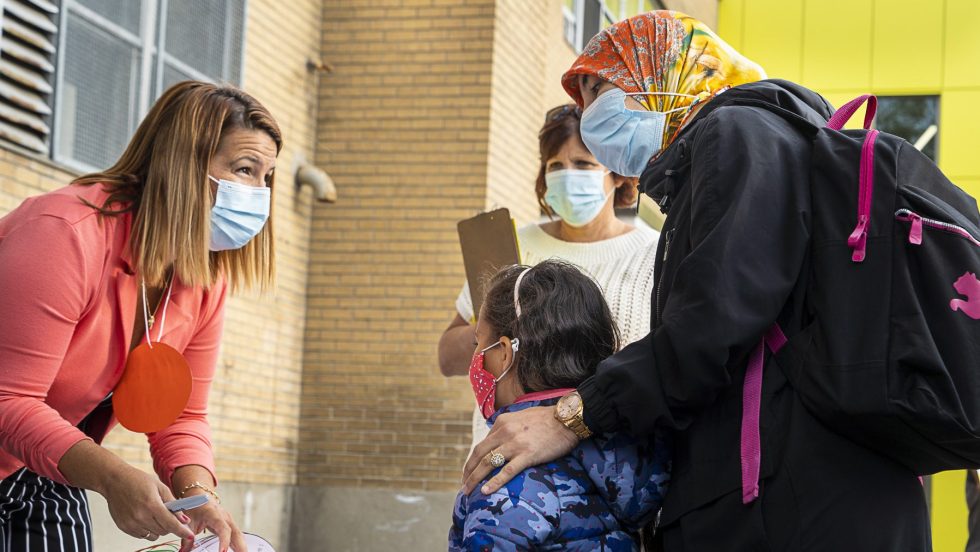 Une enfant masquée est accueillie avec sa mère à l'école primaire Philippe-Labarre, lors de la première rentrée scolaire depuis le début de la pandémie de COVID-19.