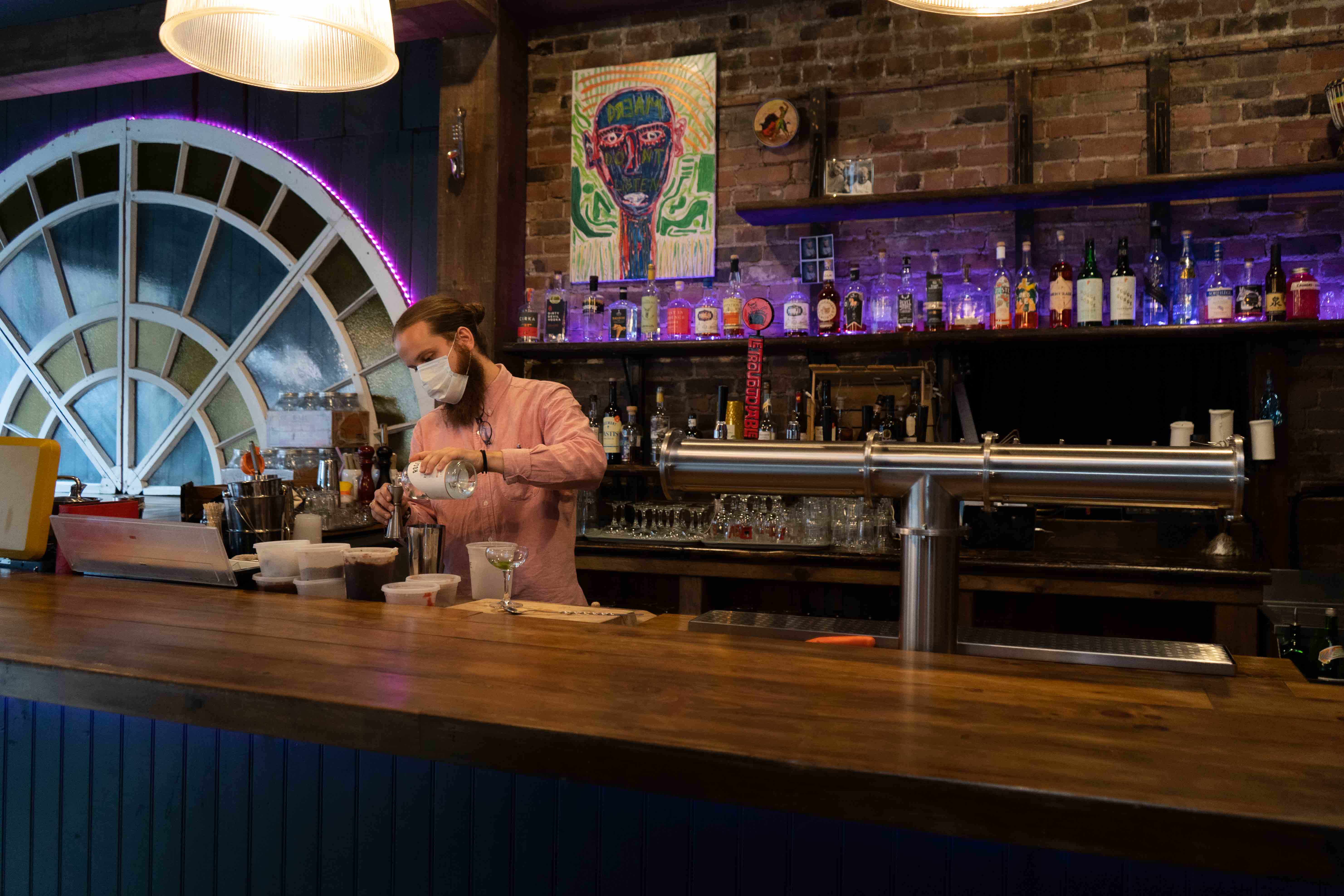 Le mixologue Justin Petitclerc pr&eacute;parant un cocktail derri&egrave;re son bar