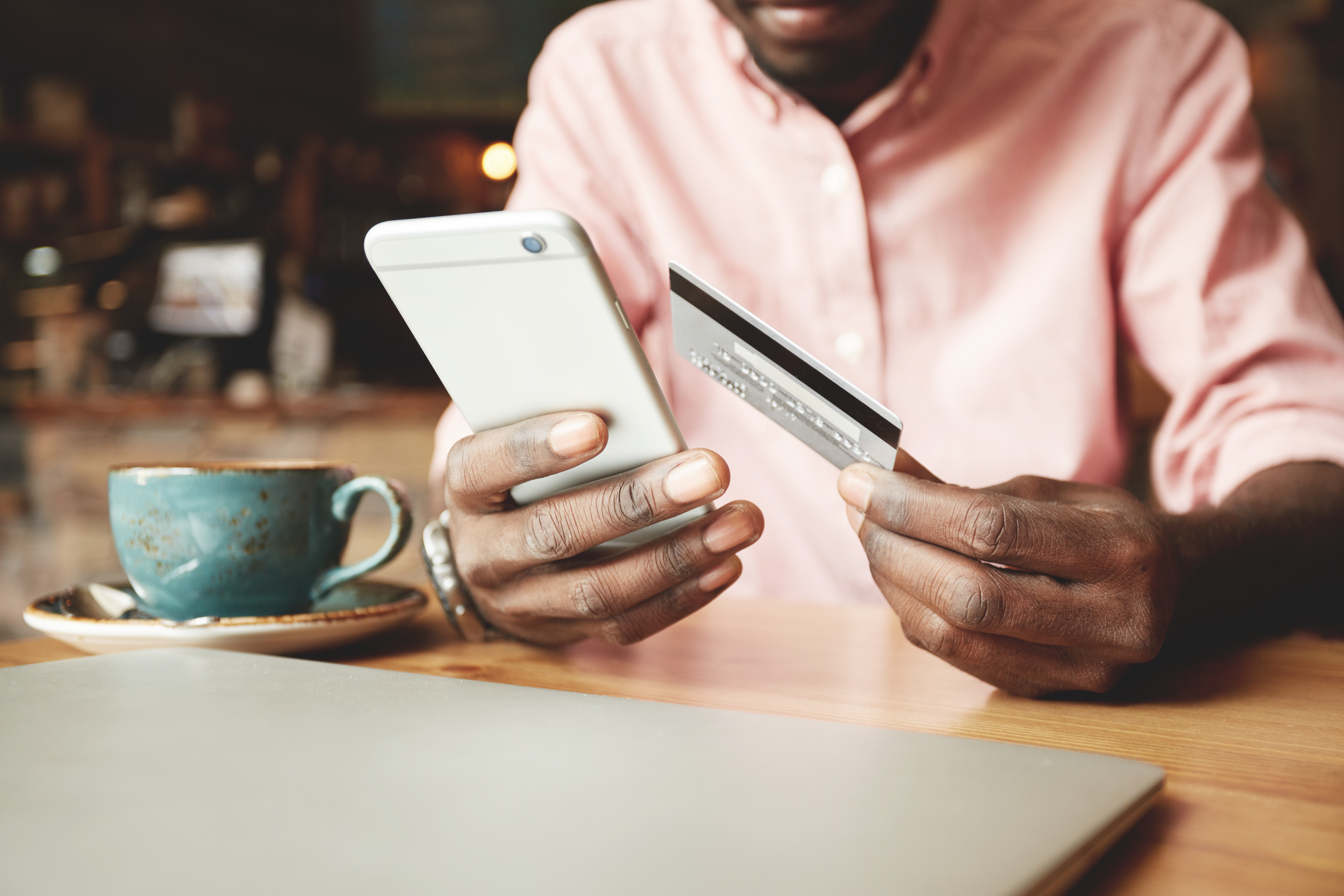 homme noir tenant une carte visa dans les mains
