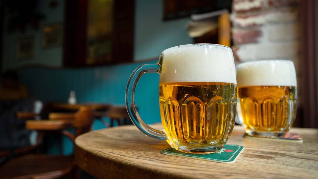 Deux verres de bières posés sur une table dans un bar