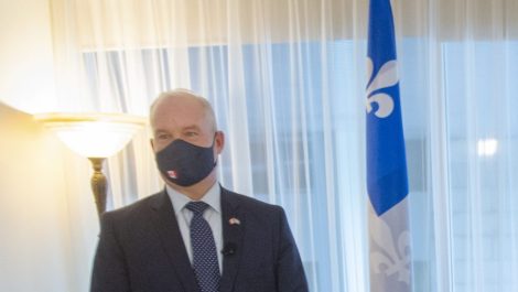 Erin O'Toole et François Legault devant des drapeaux du Québec et du Canada, portant des masques.