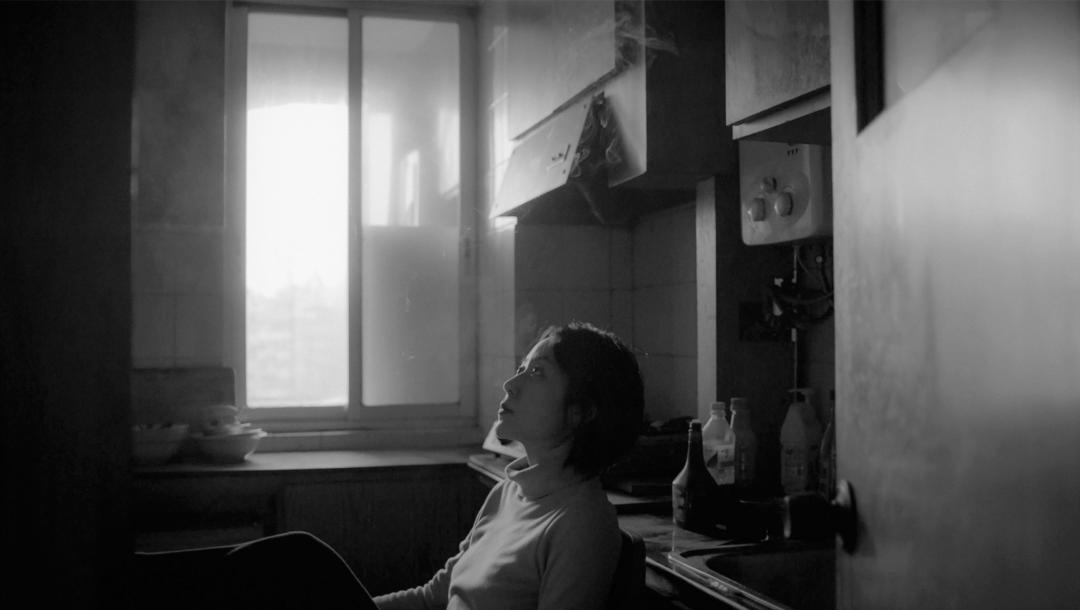 Une femme seule dans une pièce dans une capture d'écran du film The Cloud in Her Room