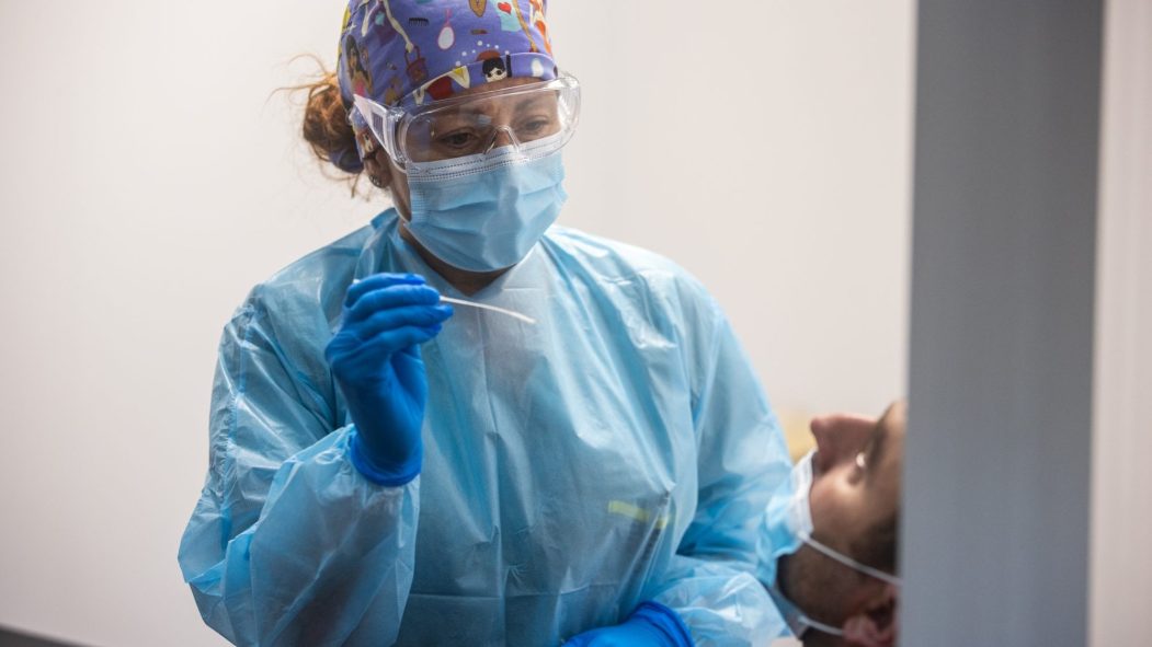 Une infirmière masquée procède à un test de dépistage du coronavirus.