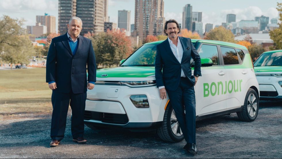 Pierre Karl Péladeau et le directeur de Téo Taxi devant un de leur véhicule électrique