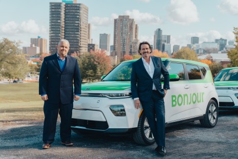 Pierre Karl Péladeau et le directeur de Téo Taxi devant un de leur véhicule électrique