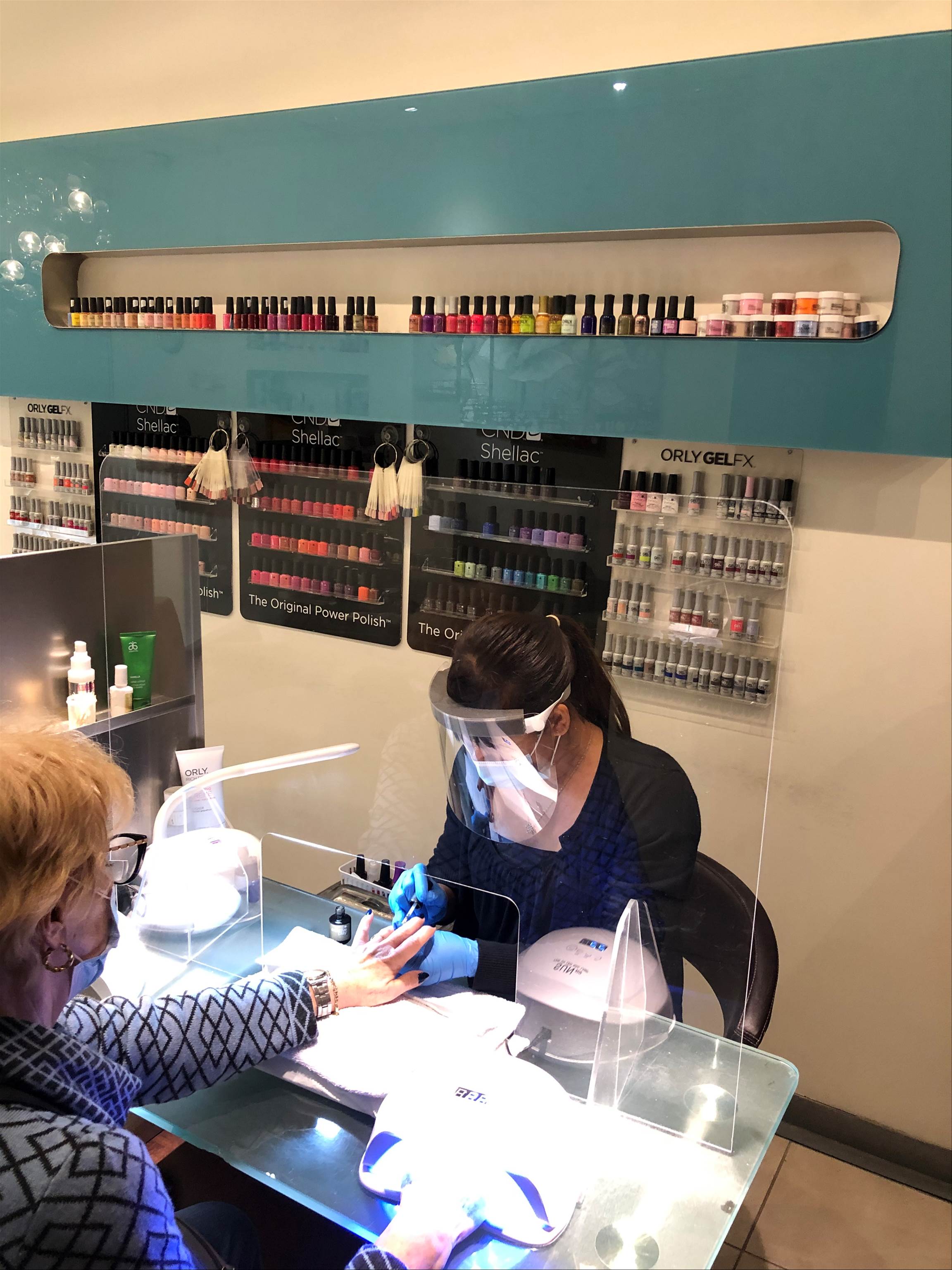 Une esthéticienne fait les ongles à une cliente au salon Ongles De L'île