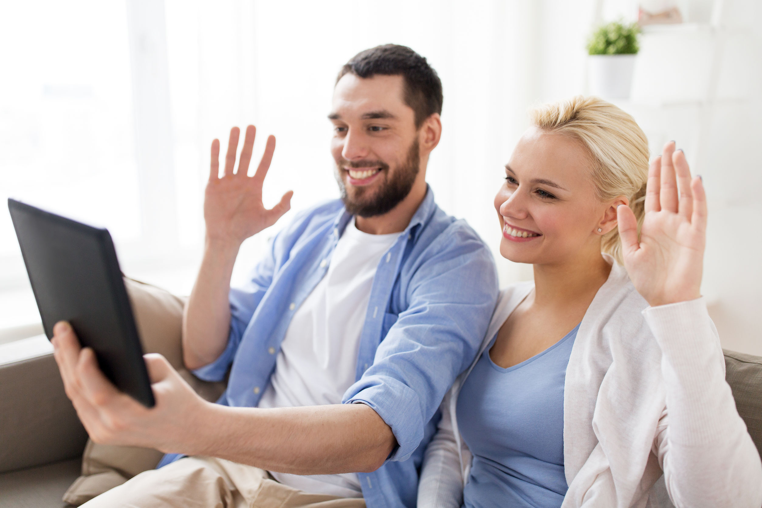 Un couple parle à quelqu'un par le biais d'une tablette