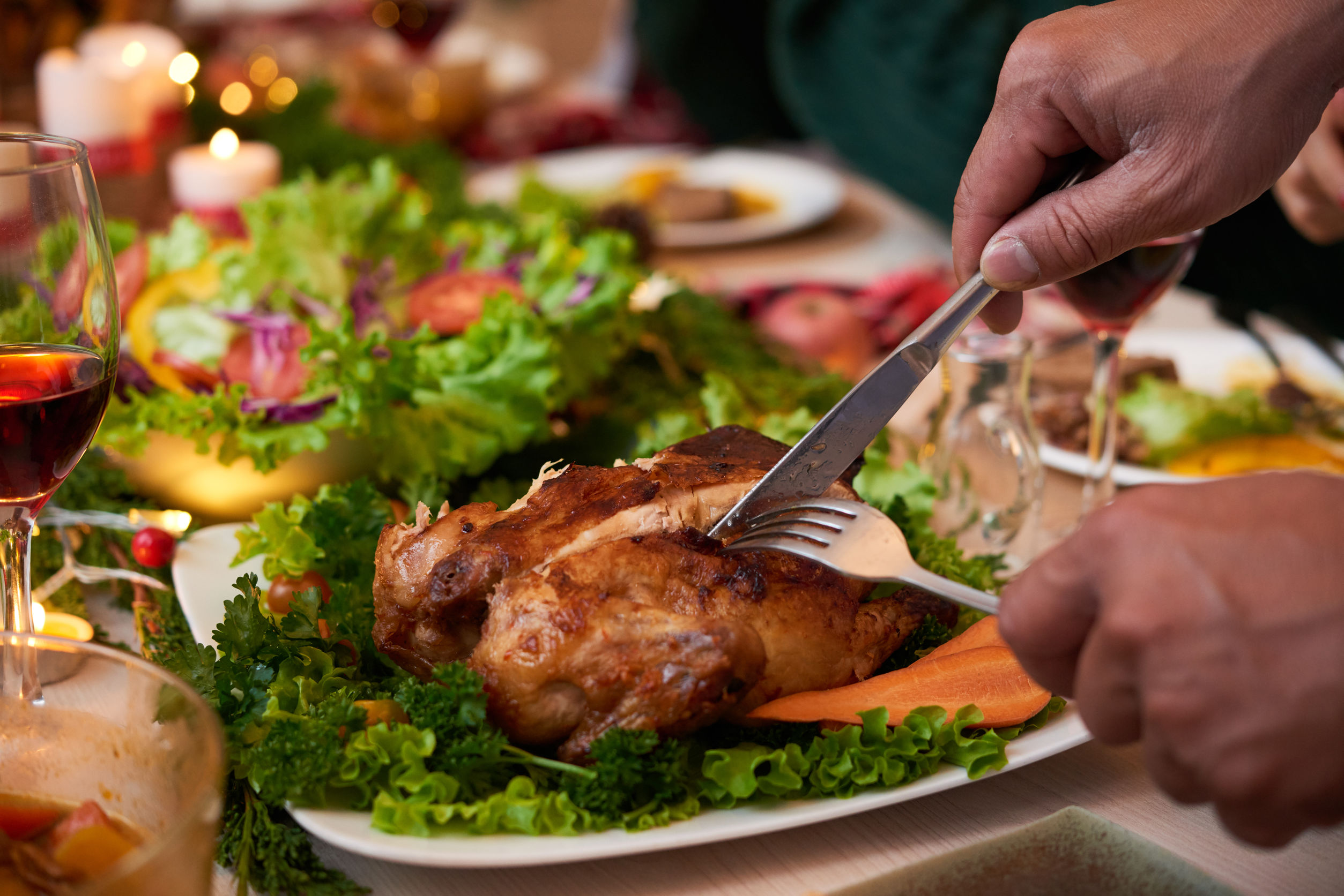 Un homme découpe un morceau de viande durant un souper des Fêtes.