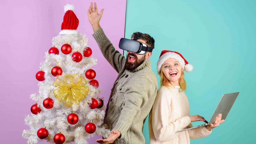 Un jeune homme et une jeune femme fêtant un Noël virtuel