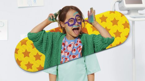 Une jeune enfant turbulente qui s'est maquillée le visage avec de la peinture