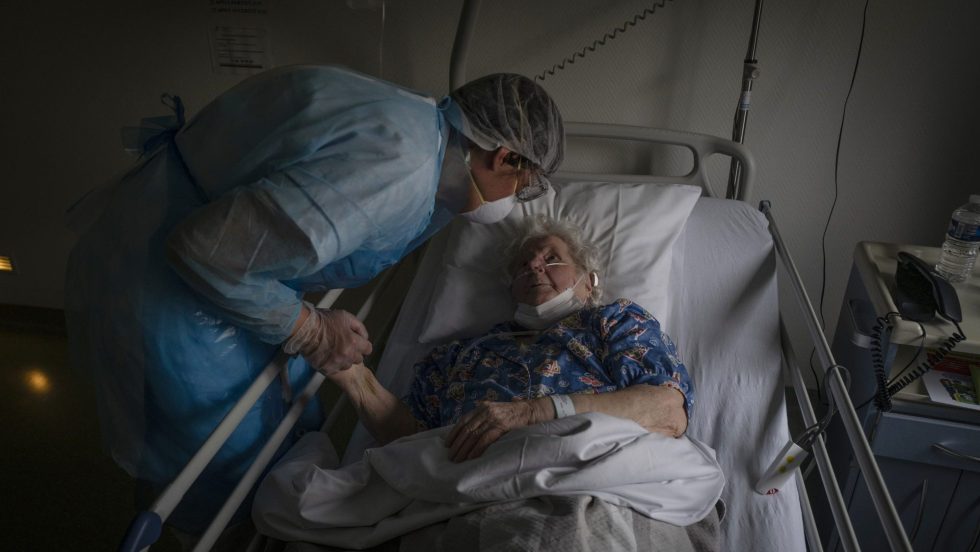 Un travailleur de la santé porte son aide à une personne âgée atteinte de la COVID-19