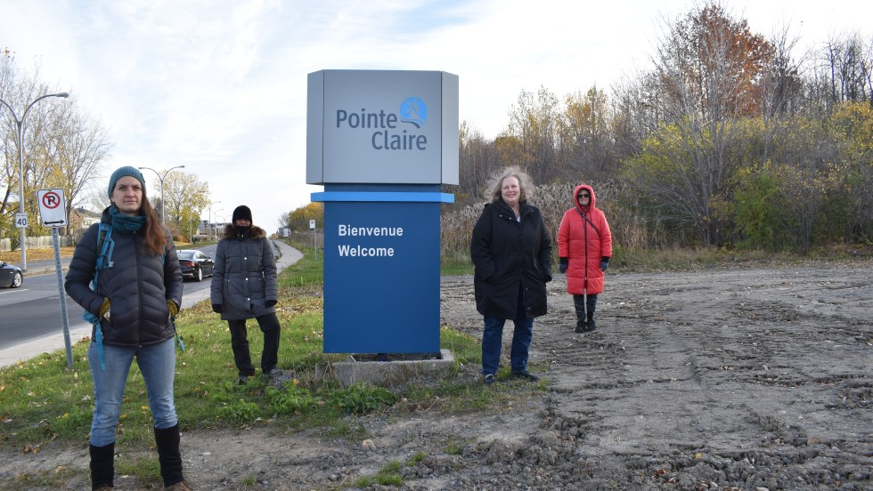 Des citoyens devant une pancarte à la forêt Fariview