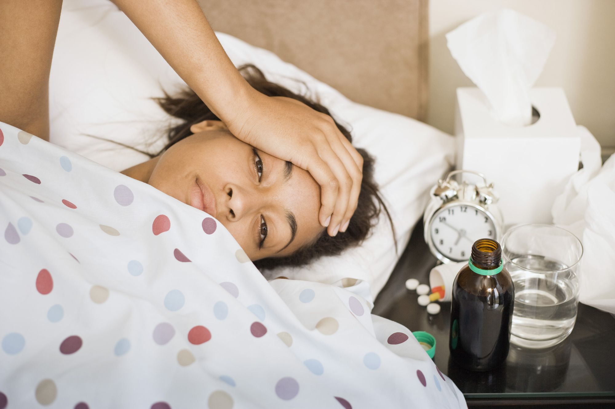 Une femme malade se repose au lit.