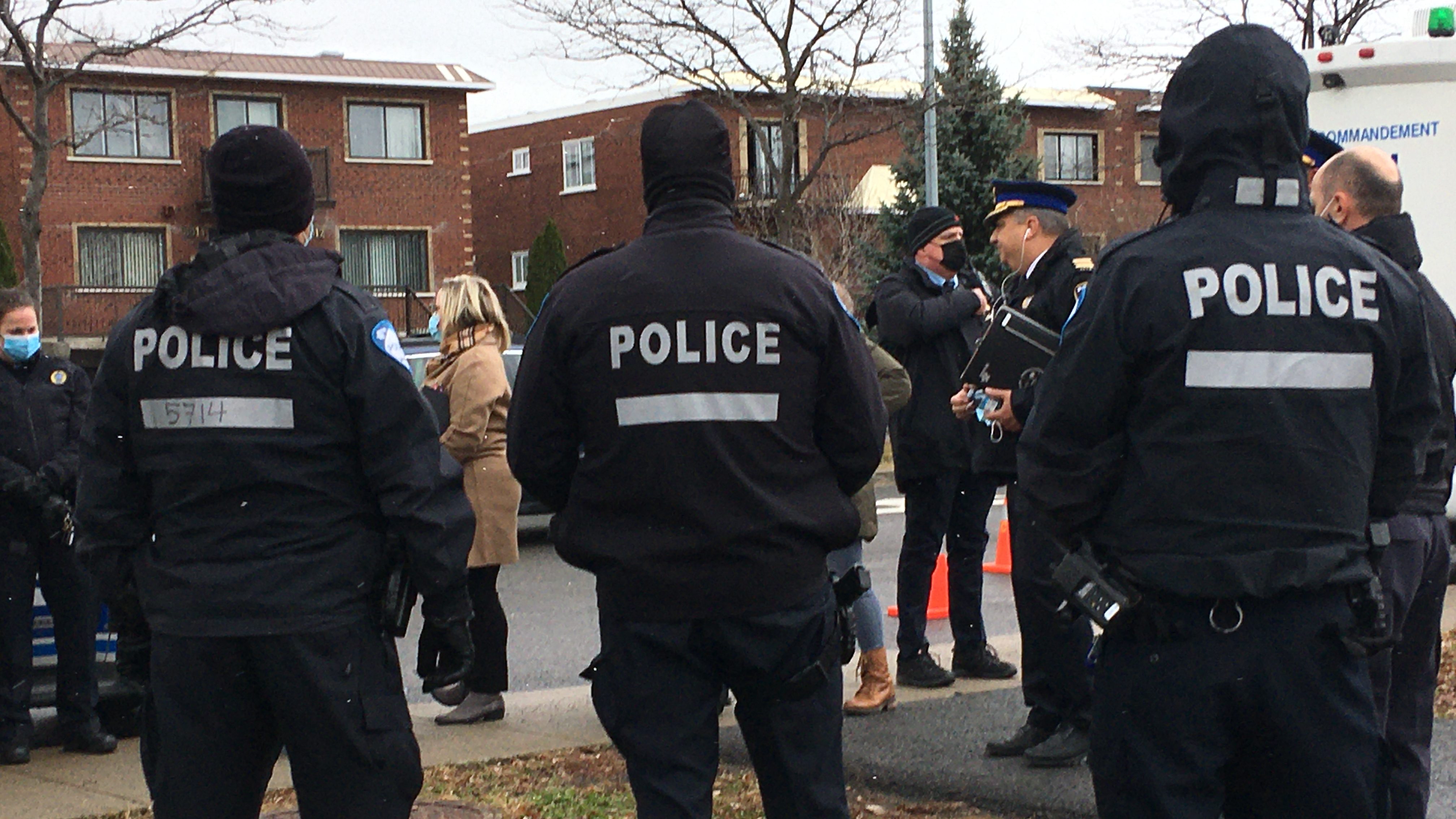 Des policiers de dos à Rivière-des-Prairies.