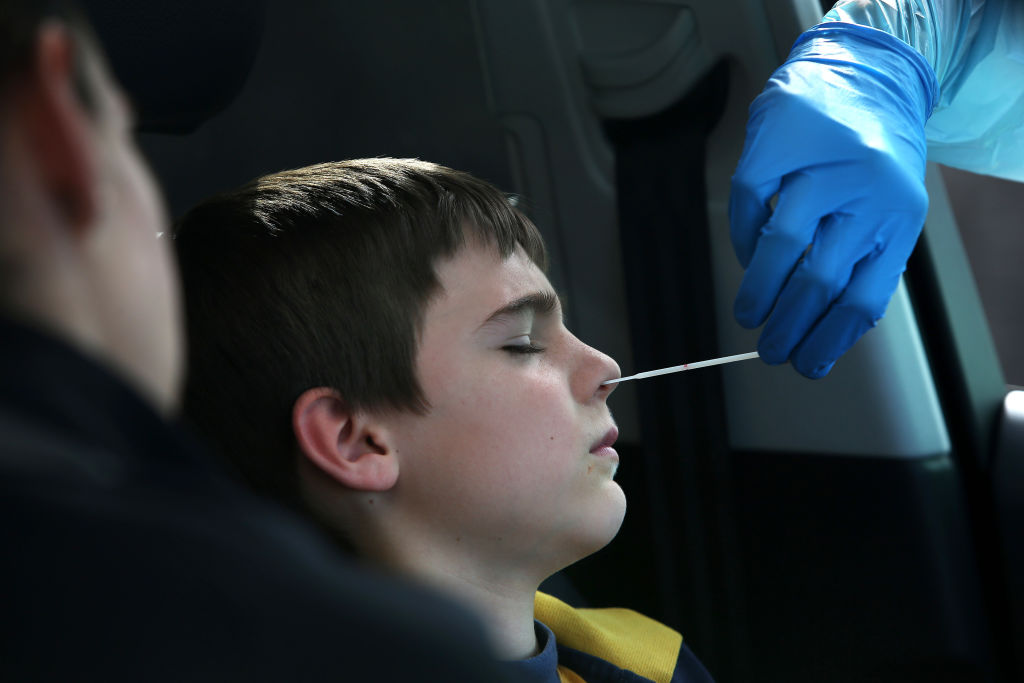 Un jeune garçon subit un test pour la COVID-19.