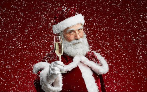Le père Noël levant sa flute de champagne.