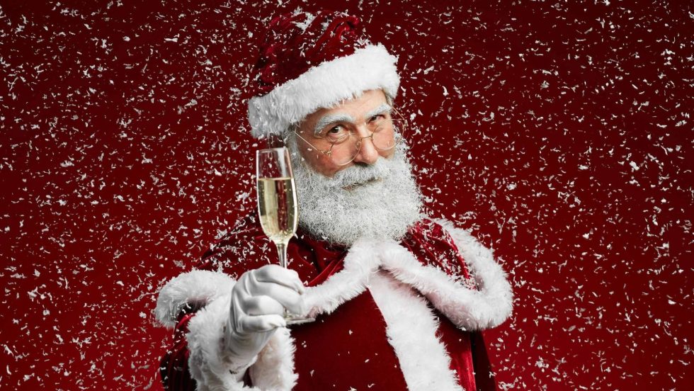 Le père Noël levant sa flute de champagne.