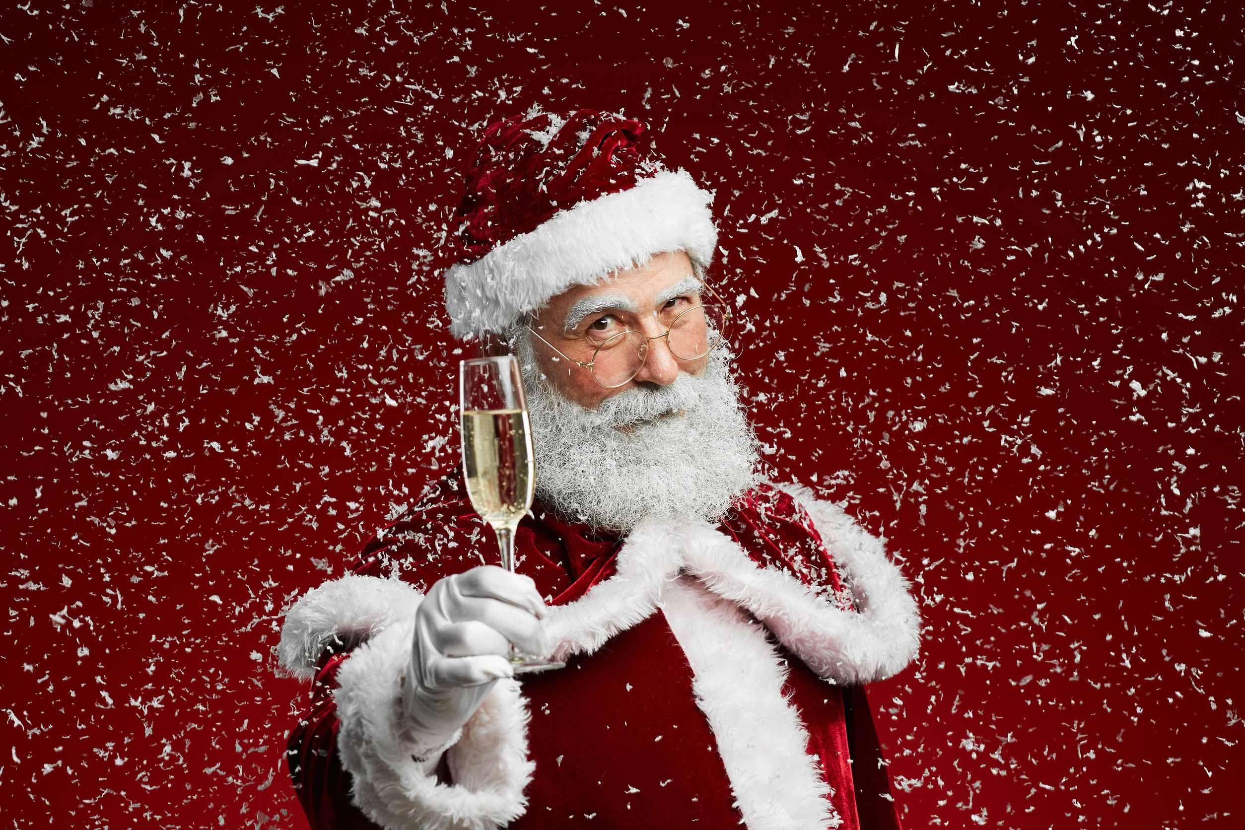 Le père Noël levant sa flute de champagne.