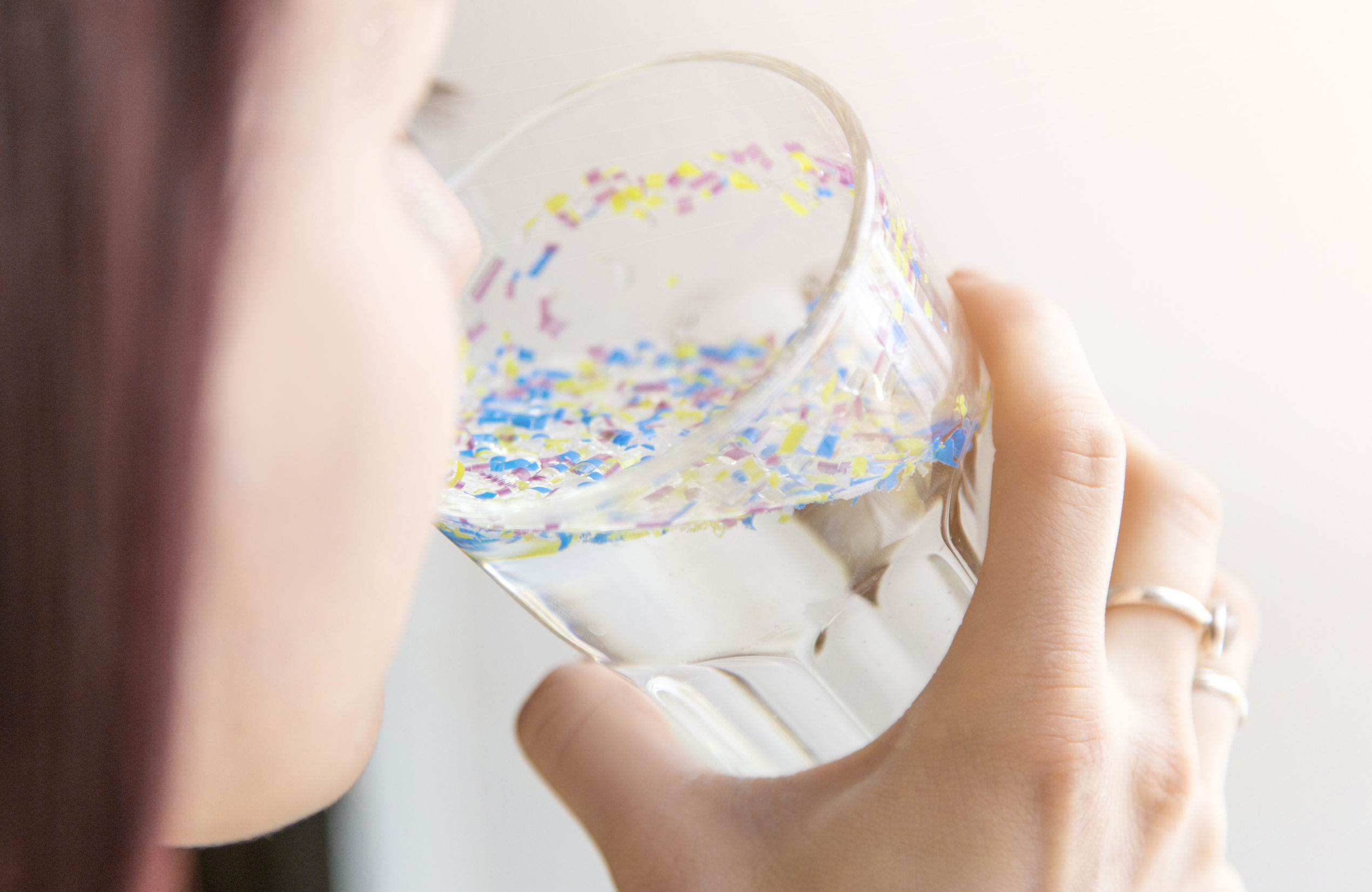 Une fille boit de l'eau polluée aux microplastiques.