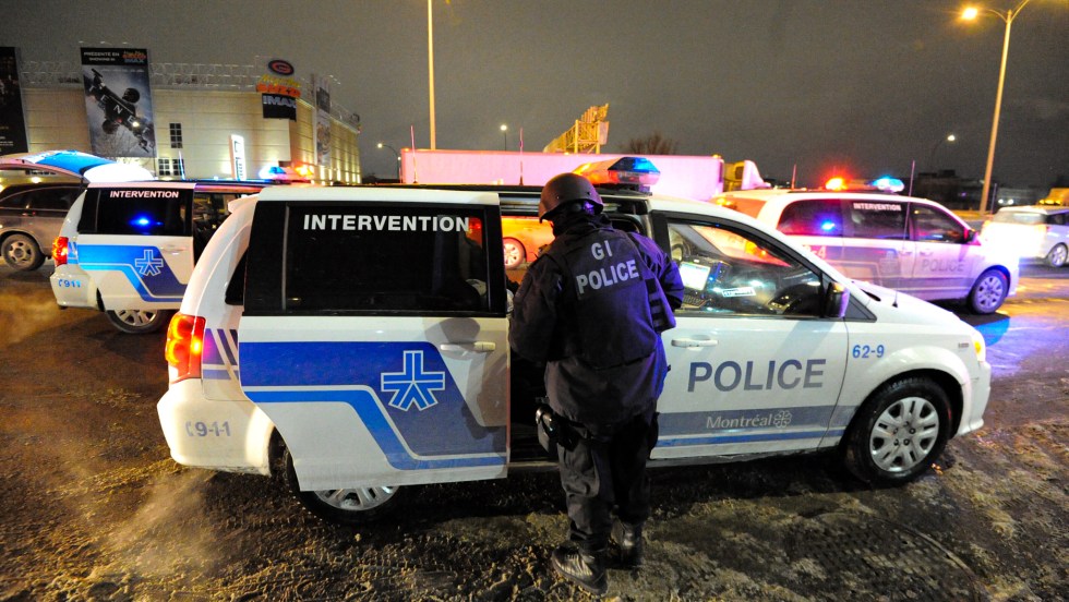 Un policier est devant un véhicule du Groupe d'intervention du SPVM est sur le boulevard Crémazie après qu'un autre policier ait été atteint par balle dans le secteur.