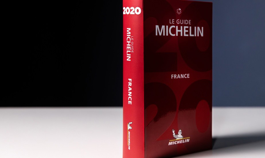 Le guide Michelin debout sur une table blanche